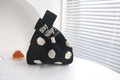 Detail of black polka dot knitted tote bag with Stay Hungry Stay Foolish text on handle - Black with White Polka Dots