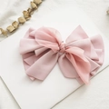 Detail of a large pink fabric and tulle bow hair clip on a minimalist white background - Light Pink Pleated