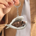 Detailed view of acrylic dachshund wing pendant keychain with metal ring held in hand - Brown Dachshund in Angel Wings (D)