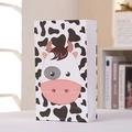 Detail view of a cartoon cow pattern gift bag with black spots and pink nose accents - Black and White Cow/811-3