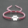 Macro detail of hand-woven pink luck cord bracelet featuring silver dog paw charm - Pink