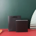 Minimalist black gift bag and matching square jewelry box set on vibrant color background - Black