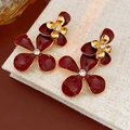 Dettaglio di orecchini a fiore rosso con bordi dorati e cristalli su fondo di lino - Orecchini a Fiore con Intarsio in Strass / Fiore Rosso Oro (45# Perno in Argento)