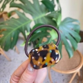 Detail eines Haarbandes aus Schildpatt mit bunten Strasssteinen auf braunem Gummiband - Tortoise