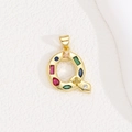 Detailed macro of gold letter Q pendant with multi-colored cubic zirconia stones - Letter Q