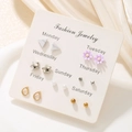 Close-up of 7-pair weekly earring set featuring stars and pearls on a branded card - Geometric Flower Weekly Set (E0454-1)