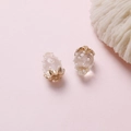 Macro shot of strawberry pendant with white pearls and gold leaves on pink background - Clear
