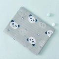 Gray cotton muslin baby swaddle blanket featuring dark blue panda and paw prints - Panda