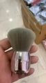 Pinceau à maquillage court avec poils gris et manche en métal argenté brillant en main - Tête Ronde Argent