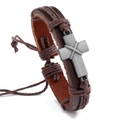 Detailed macro view of woven brown leather bracelet with an antique metal cross charm - Cross