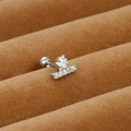 Macro view of silver steel cartilage stud featuring star and bar set with white zircons - Star with Bar