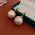 Elegante vergulde pareloorbellen met grote witte ronde parels op groen fluweel - Echt Verguld Goud (Zilveren Naald)