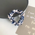 Blue and white leopard print satin scrunchie shown on a black plate with aesthetic background - Pink Leopard