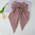 Detail of large leopard print bow hair clip with ribbons on a soft lavender background - Pink Leopard