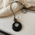 Detailed close-up of a long faux leather cord necklace with black pendant in a jewelry box - 41# Necklace Black Ring Brown Bead