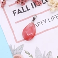Waterdrop shaped pink watermelon crystal pendant with silver clasp on artistic background - Watermelon Quartz