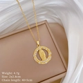 Detailed close-up of golden portrait pendant with crystals on elegant beige box - Virgin Mary Round Style (E151)