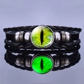 Macro shot of steampunk dragon eye glowing leather bracelet with green glass cabochon - Green Cat's Eye