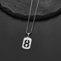 Macro shot of silver stainless steel number 8 pendant hanging over dark textured stone - Number 8