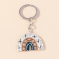 Rainbow acrylic keychain with eyes and stars in earth tones on a beige background - Brown Leopard Rainbow