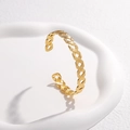 Detail of the golden C-shape woven texture on an adjustable stainless steel cuff bangle - Gold