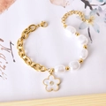 Golden chain bracelet with irregular baroque pearls and a sparkling white flower charm - Five-petal Flower