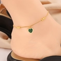 Détail d'une chevillère dorée avec pendentif cœur vert et perles sur le modèle - 6 # Amour