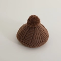 Macro-opname van de donkerbruine gebreide baret met dikke textuur en pluizige pompon - 50-52cm (2-5 Jaar) / koffiekleur