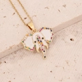 Macro view of gold elephant pendant featuring colorful zircon stones and white enamel detail - White