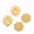 Dettaglio macro di quattro copriperla dorati a forma di fiore per la creazione di gioielli - Stile 05 (10x10mm) / Set da 20 Pezzi