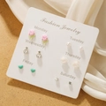 Set of six butterfly and pearl stud earrings displayed on elegant beige silk fabric - Resin Pearl Alloy Stud Earrings Combo (E0058-1)