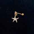 Detail view of a gold starfish earring with pavé zircon charms on black velvet - Gold-Starfish