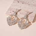 Detail of silver drop earrings with marquise-cut rhinestones on beige stone - Silver