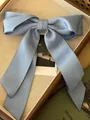 Elegant dusty blue satin bow hair clip with long ribbons on a minimalist display - Fresh Blue