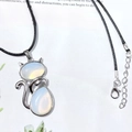 Silver cat pendant necklace featuring translucent opal stones on a black leather cord - Opalite
