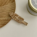 Brown and beige teardrop hair clip with striped diamond pattern on wooden tray - Argyle Brown