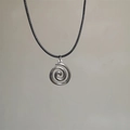 Zilveren zon ster swirl hanger ketting met zwart koord op een strakke achtergrond - Roestvrijstalen Wervel Stijl