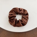 Detail of a dark brown satin scrunchie with silky texture on a white round tray - Large / Chestnut