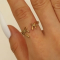 Detailed close-up of a golden bow-shaped open ring on a model's middle finger - Polished Minimalist Bow Open Ring (WG0101)