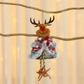 Dettaglio di renna natalizia in peluche con campanellini appesa a un ramo di un albero - Cervo