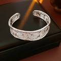 Detail van zilveren open armband met geweven textuur op een zwart sieradendoosje - Verzilverd Geweven Structuur / Zilver