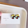 Détail de boucles d'oreilles de Noël mignonnes avec un nœud jaune sur une carte blanche - Donut de Noël - Clou