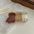 Detail shot of cute puppy hair claw clip with Ideal Cycle text on creamy resin - Brown Dog Claw