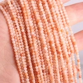Macro detail of natural pink-orange round mineral stone beads with unique textures - Pink Aventurine