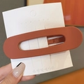 Matte brick red oval hollow hair clip on display card for minimalist styling - Orange