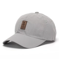 Detail view of grey quick-dry mesh baseball cap with brown faux leather brand patch - Light Gray