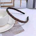 Detailed view of dark brown braided headband with metallic texture on white tabletop - Dark Coffee