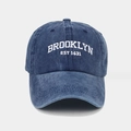 Detailed macro view of white BROOKLYN EST 1631 embroidery on washed cotton baseball cap - Navy Blue