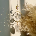 Detail of crystal suncatcher casting rainbow light on wall with natural white quartz pendant - White Crystal