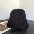 Detalle del tejido de ganchillo calado en un sombrero bucket de punto negro suave - Negro